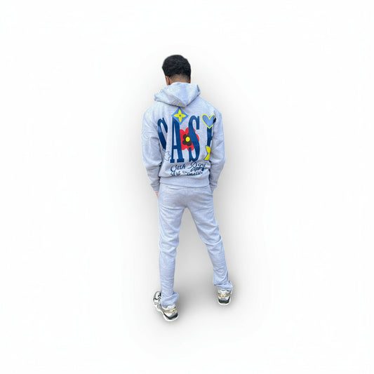 Person wearing a light blue tracksuit with colorful text on the back against a white background