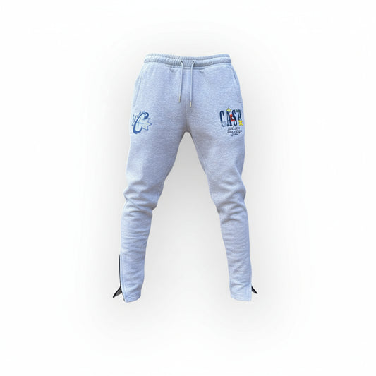 Light gray sweatpants with brand logos worn by a person on a white background